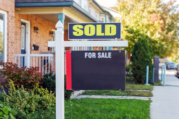 Naklejka premium Sold sign in front of a house in a residential neighborhood in summer. Copy space for text