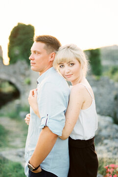 Woman From Behind Hugs Man In Park. Portrait