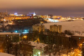 evening winter city, embankment with illumination, high-rise buildings