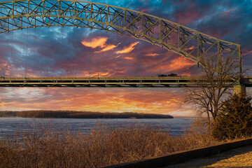 the Memphis & Arkansas Bridge over the vast flowing waters of the Mississippi river with a blue and...