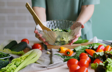 person preparing vegetables. Salad. Kitchen ingredients. Healthy food. Vegan menu. Raw food. Ready to eat. Spring vitamins 