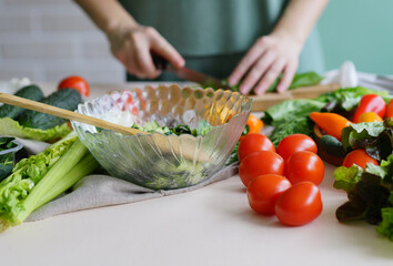 person cutting vegetables. Kitchen ingredients. Vegan menu, healthy food. Spring vitamins 