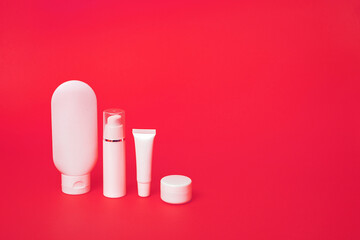 Closeup of white tubes for various cosmetics on a pink background. With copy space.