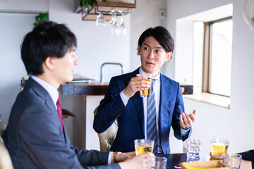 お酒を飲みながら話すビジネスパーソン