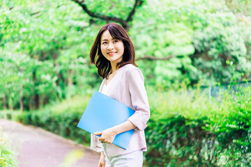 書類を持って歩く若いビジネスウーマン