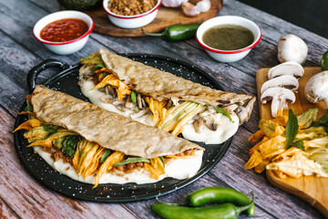 Mexican chicharrón quesadilla with oaxaca cheese and squash blossom, traditional food from the city of Puebla in Mexico