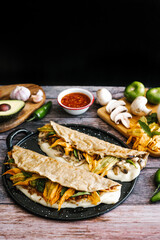 Mexican chicharrón quesadilla with oaxaca cheese and squash blossom, traditional food from the city of Puebla in Mexico