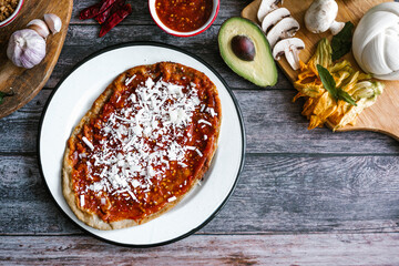 Memela sope quesadilla poblana of red sauce with cheese, onion and avocado traditional mexican food from Puebla, Mexico