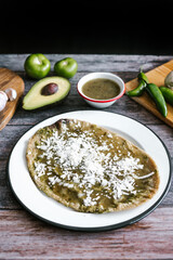 Memela sope quesadilla poblana of green sauce with cheese, onion and avocado traditional mexican food from Puebla, Mexico