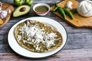 Memela sope quesadilla poblana of green sauce with cheese, onion and avocado traditional mexican food from Puebla, Mexico