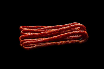 Cabanossi, dry sausage isolated on black background.