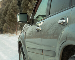 Silver-colored car, SUV, driving on a snowy winter road in the forest