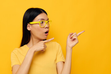 Obraz premium pretty brunette in yellow t-shirts with glasses posing fashion isolated background unaltered
