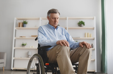 Upset Caucasian senior man in wheelchair having depression indoors