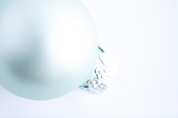 light turquoise colored bauble against white background