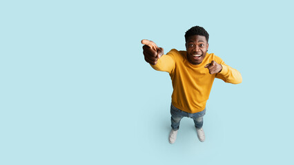 Happy african american man showing copy space, top view