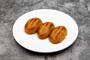 Traditional Turkish dessert sekerpare on a dark background. Turkish dessert with syrup, ramadan and feast treat. Close up