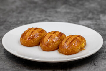 Traditional Turkish dessert sekerpare on a dark background. Turkish dessert with syrup, ramadan and feast treat. Close up