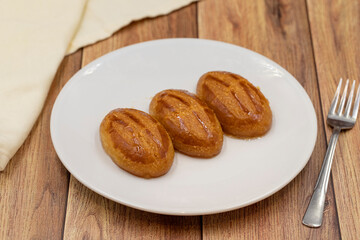 Traditional Turkish dessert sekerpare on a wooden background. Turkish dessert with syrup, ramadan and feast treat. Close up