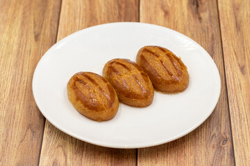 Traditional Turkish dessert sekerpare on a wooden background. Turkish dessert with syrup, ramadan and feast treat. Close up