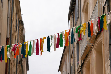 many colorful pieces of fabric hanging in street Montpellier France