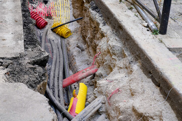 cable underground during works electrical gas and telecommunications cables and water pipes on the street - obrazy, fototapety, plakaty