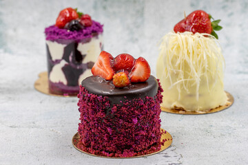 Patisserie cakes. Banana, Chocolate and Fruit Cakes on a grey background.
