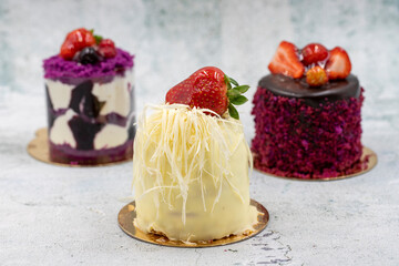 Patisserie cakes. Banana, Chocolate and Fruit Cakes on a grey background.