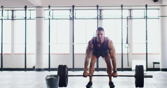 The place where muscles are made. Muscular young man lifting weights at the gym. Bodybuilder sportsman working out with a barbell in gym. Handsome caucasian man lifting heavy weights, training