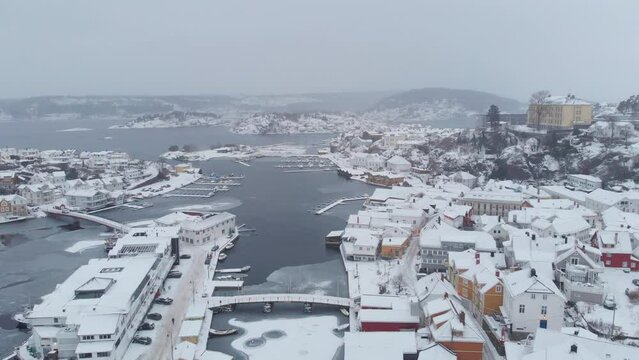 Flying Over Snow Covered City Of Kragerø In Norway During Winter - drone shot