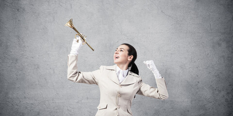 Beautiful woman holding trumpet brass overhead