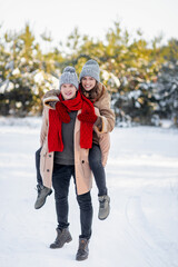 Happy loving couple enjoying snowy winter day at park together