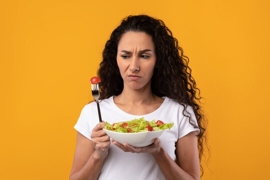 Portrait of Sad Latin Lady Holding Plate With Vegetable Salad