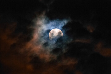 moon at night covered by clouds carried by the wind. copy space for life quotes and religion,...