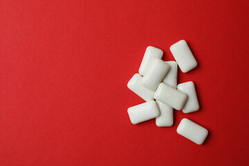 Chewing gum on red background, space for text