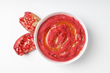 Plate of beet hummus on white background, top view