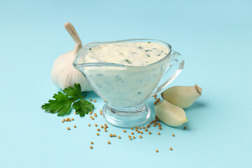 Garlic sauce and ingredients on blue background