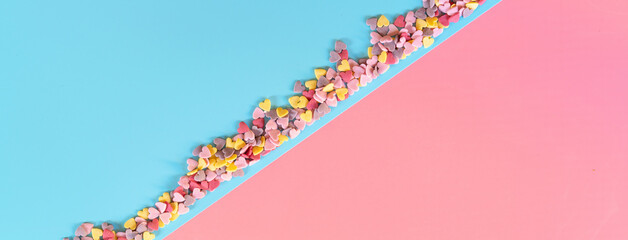flatlay mockup made of multi-colored sugar hearts on a turquoise background in the form diagonally divides the sheet in half