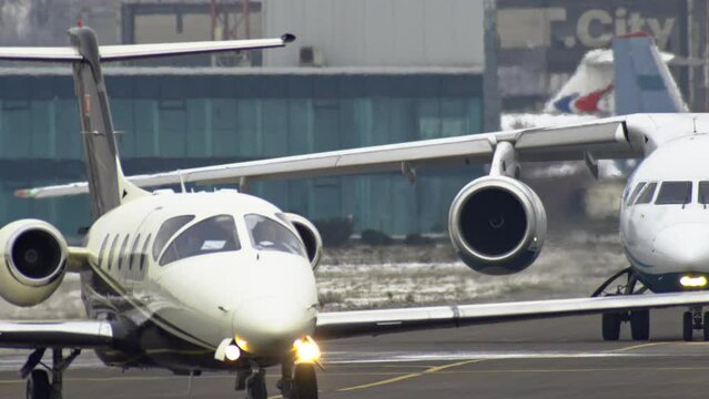 Slow motion video of a small private plane traveling through the airport in the winter.