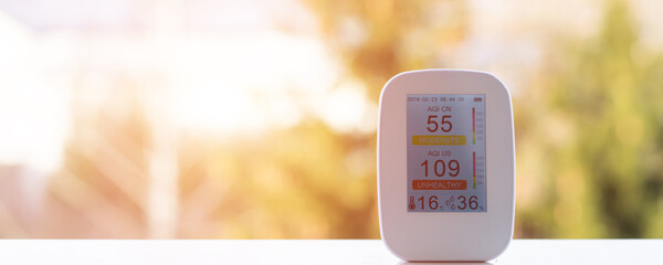 air quality meter on the windowsill shows poor quality at sunrise in the early morning
