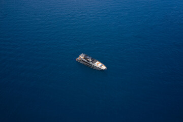Big gray super boat on the water aerial view. Big yacht for millionaires in the sea drone view. Luxurious gray blue Mega yacht on dark water top view.