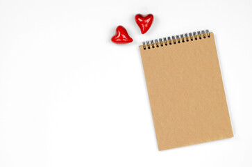 The concept of Valentine's day, mother's day. Blank notepad with craft paper on a white background with hearts. Blank for congratulations or invitations.