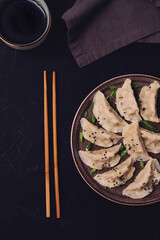 Japanese Gyoza dumplings , with sauce, on a black background, top view, no people, toned,