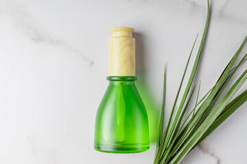 Dropper glass Bottle Mock-Up. Fece treatment and spa. Natural beauty products. Beauty serum, skin care blank green frosted glass bottle. Marble background with green tropical leaves.
