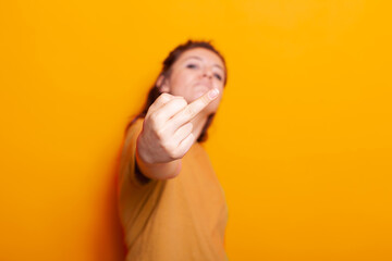 Angry woman showing offensive middle finger on camera. Irritated person doing vulgar gesture with...