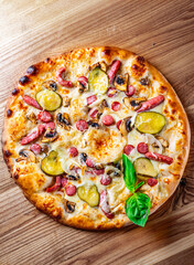 Pizza with Mozzarella cheese, salami, chicken meat, beef, ham, Tomato sauce, pepper, spices. Italian pizza on wooden background