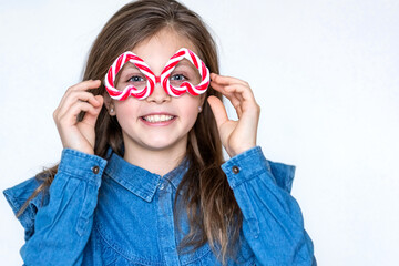 Funny happy girl child in inverted caramel glasses looks at the camera with hearts and smiles. Copy...