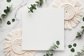 Mockup with blank square canvas, copy-space. Eucalyptus twigs, macrame pads.Winter flat lay background . Top view on white marble - obrazy, fototapety, plakaty