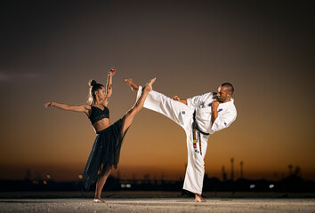 Beautiful girl gymnast and karate fighter practicing kick in flight at sunset