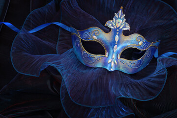 Photo of elegant and delicate Venetian mask over blue dark background - obrazy, fototapety, plakaty